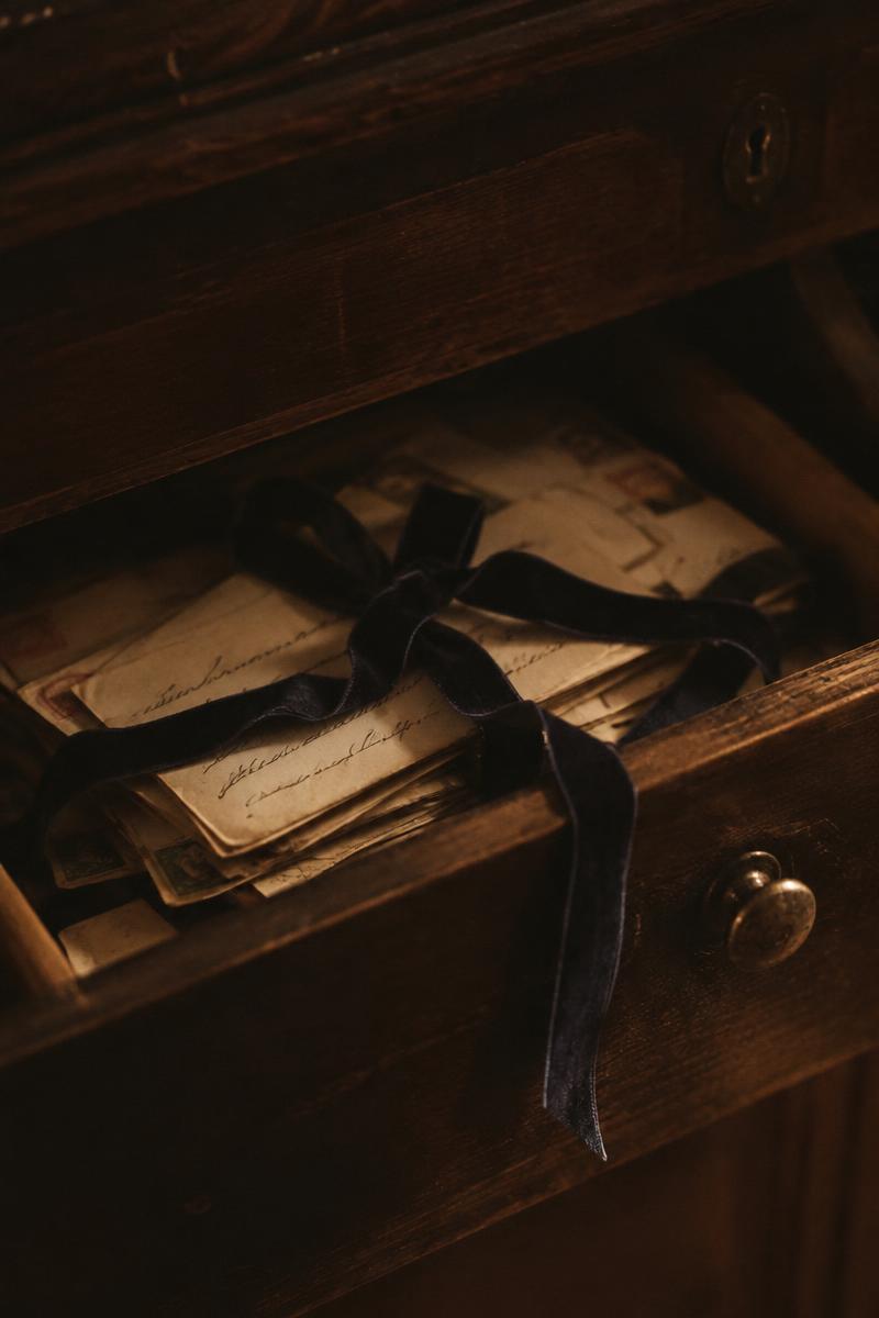 An old wooden drawer full of letters tied with a ribbon